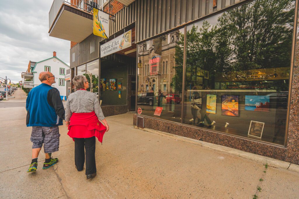 UN couple se promène sur l'avenue de Grand-Mère devant les boutiques