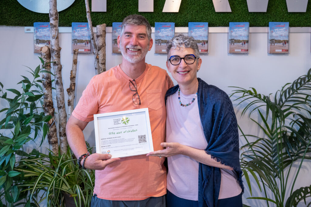 Anaïs Laurent remet un certificat de reconnaissance au propriétaire du gîte aux Orchidées